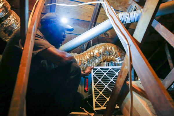 Darrell Word, technician and co-owner of Maintenance Unlimited Heating & Cooling, services an AC unit in College Park on Friday, July 28, 2023. (Katelyn Myrick/katelyn.myrick@ajc.com)