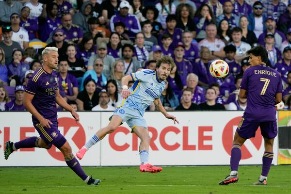 Atlanta United's Saba Lobzhanidze, center, kicks the ball between Orlando City's Robin Jansson, left, and forward Ramiro Enrique (7) during the second half of an MLS Semifinal Conference playoff soccer match, Sunday, Nov. 24, 2024, in Orlando, Fla. (AP Photo/John Raoux)