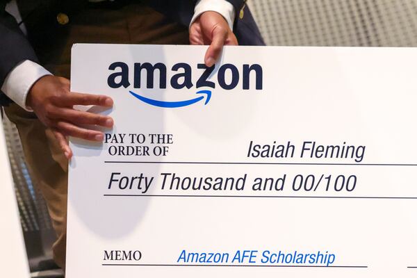 Arabia Mountain High School senior Isaiah Fleming holds his oversized check after he and seven others received a $40,000 Amazon Future Engineer Scholarship and paid internship at Amazon at the Junior Achievement Discovery Center at the Georgia World Congress Center, Tuesday, April 18, 2023, in Atlanta. Students represented the Atlanta Public Schools, Clayton County Public Schools, and DeKalb County Schools. Jason Getz / Jason.Getz@ajc.com)