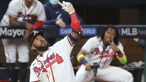 Ronald Acuna (rear) reacts as Marcell Ozuna pauses to pretend he is taking a selfie after his solo homer in the playoffs. 