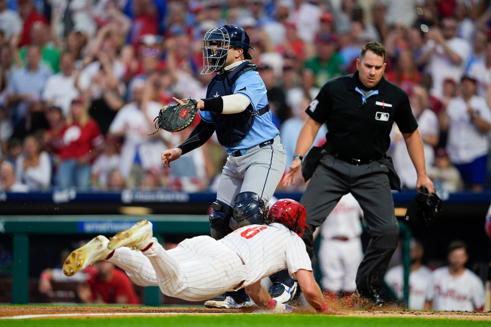 Philadelphia Phillies' Brandon Marsh, bottom, scores past Tampa Bay Rays' Logan Driscoll on a ball hit by Phillies' Johan Rojas during the second inning of a baseball game, Tuesday, Sept. 10, 2024, in Philadelphia. (AP Photo/Derik Hamilton)