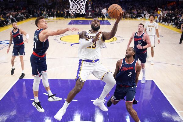 Los Angeles Lakers forward LeBron James, center, shoots as Los Angeles Clippers guard Bogdan Bogdanovic, second from left, and forward Kawhi Leonard defend during the first half of an NBA basketball game Sunday, March 2, 2025, in Los Angeles. (AP Photo/Mark J. Terrill)