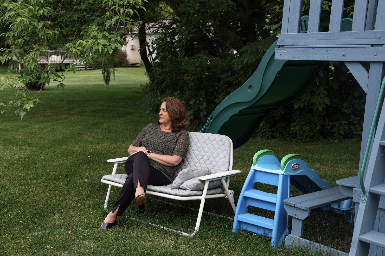 Tina Barton, the former city clerk of Rochester Hills, Mich., sits next to her grandchildrens’ playset on Tuesday, June 11, 2024. Barton is one of many election officials nationwide who have been threatened with violence since 2020. (Photo by Olivia Talkington/News21)