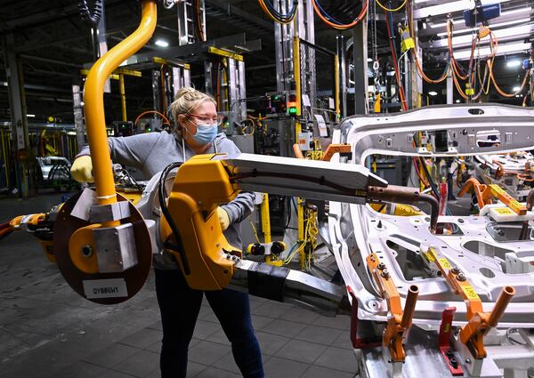 FILE - GM workers use human assistance automation to weld vehicle doors at the General Motors assembly plant during the COVID-19 pandemic in Oshawa, Ontario, March 19, 2021. (Nathan Denette/The Canadian Press via AP, File)