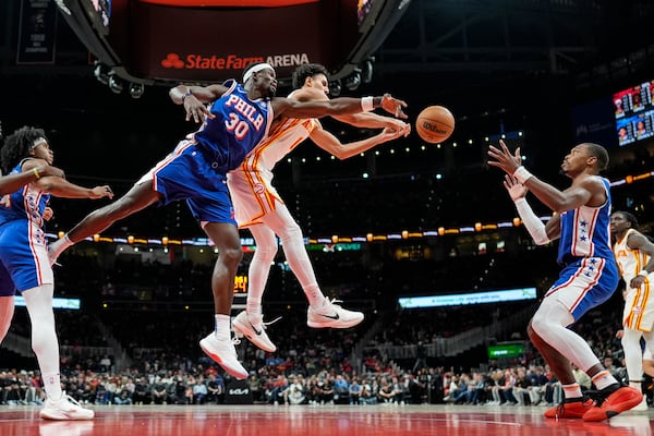 Atlanta Hawks forward Zaccharie Risacher (10) and Philadelphia 76ers center Adem Bona (30) vie for a rebound during the first half of an NBA basketball game, Monday, March 10, 2025, in Atlanta. (AP Photo/Mike Stewart)