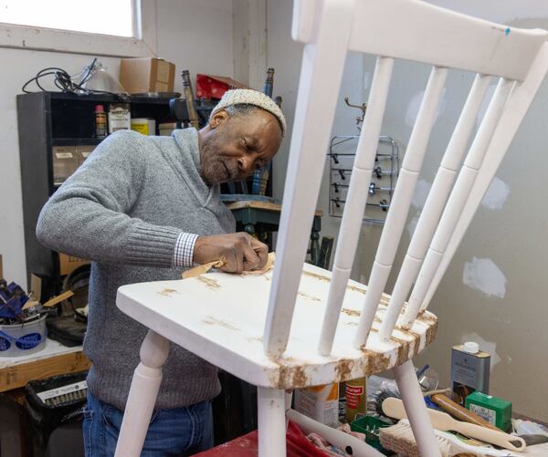 Larry Jordan sands a chair before painting it. 
 PHIL SKINNER FOR THE ATLANTA JOURNAL-CONSTITUTION