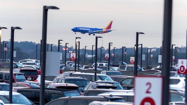 A Southwest Airlines plane lands near a full parking area at Hartsfield-Jackson International Airport. (Steve Schaefer/AJC 2023)