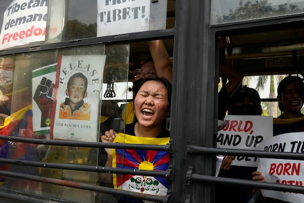 A Tibetan exile shouts slogans from the bus after she is detained and taken to police station during a protest outside Chinese embassy to mark the 1959 uprising in Tibet against the Chinese rule on this day, in New Delhi,India, Monday, March, 10, 2025. (AP Photo/Manish Swarup)