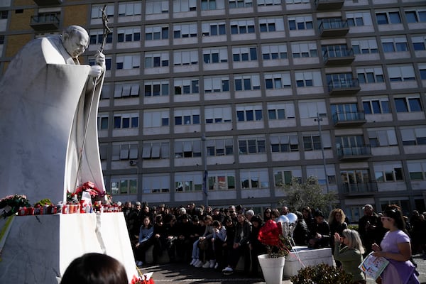 People pray outside the Agostino Gemelli Polyclinic in Rome, Sunday, Feb. 23, 2025, where Pope Francis is hospitalized since Feb. 14. (AP Photo/Gregorio Borgia)