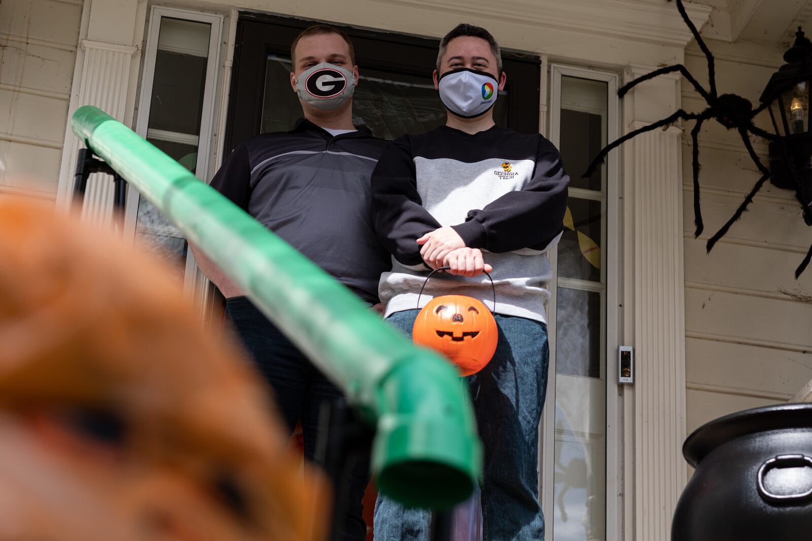 Heath Hall (left) and Ben Ku aren’t sure how many trick-or-treaters they will get this year at their Tucker home, so they built a chute to deliver candy while keeping socially distanced on Halloween. Ben Gray for the AJC