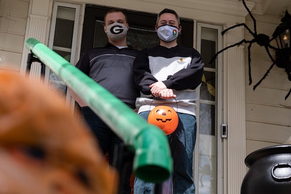 Heath Hall (left) and Ben Ku aren’t sure how many trick-or-treaters they will get this year at their Tucker home, so they built a chute to deliver candy while keeping socially distanced on Halloween. Ben Gray for the AJC