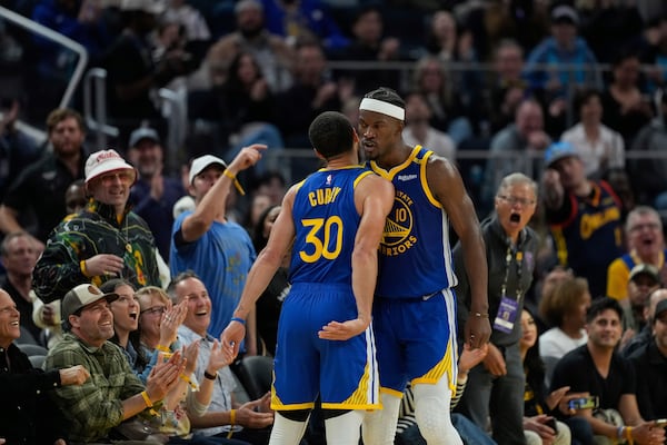 Golden State Warriors forward Jimmy Butler III, right, celebrates with guard Stephen Curry (30) after scoring during the first half of an NBA basketball game against the Dallas Mavericks, Sunday, Feb. 23, 2025, in San Francisco. (AP Photo/Godofredo A. Vásquez)