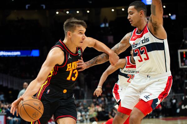 Bogdan Bogdanovic (13) moves the ball past Washington Wizards Kyle Kuzma (33) during the first half of an NBA basketball game on Monday, Nov. 1, 2021, in Atlanta. (AP Photo/Hakim Wright Sr.)