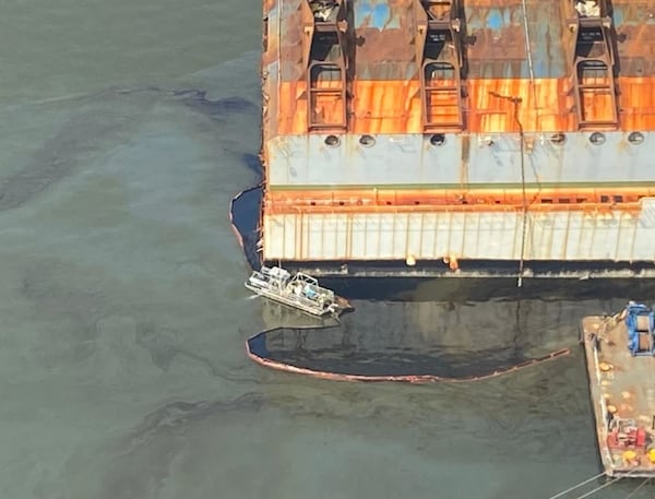 A MARCO oil skimmer vessel attaches to retention boom around the remainder of the Golden Ray wreck in order to remove oil retained inside the boom on Monday, August 2, 2021. Several oil spills from the ship contaminated beaches and marshlands on the Georgia coast.