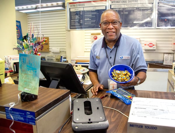 Postal clerk Russel Lewis holds a bowl full of spicy ginger candy that he kept on the counter for his customers at the Avondale Estates post office. Lewis has just retired after 24 years on the job. STEVE SCHAEFER FOR THE ATLANTA JOURNAL-CONSTITUTION