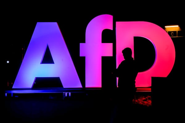 A man stands in front of the logo at the AfD party headquarters in Berlin, Germany, Sunday, Feb. 23, 2025, after the German national election. (AP Photo/Michael Probst)