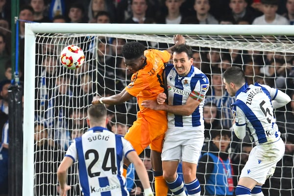 Real Sociedad's Mikel Oyarzabal, centre, challenges for the ball with Real Madrid's Aurelien Tchouameni during the Spanish Copa del Rey soccer match between Real Sociedad and Real Madrid at the Reale Arena in San Sebastian, Spain, Wednesday, Feb. 26, 2025. (AP Photo/Miguel Oses)