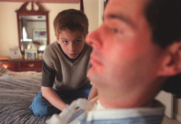 David Jayne talks with his son Hunter. Jayne uses a computer which does his speaking for him. Even though his son often looks at the computer screen when talking with his father, most of the time he looks directly at his dad. (RICH ADDICKS / Staff)