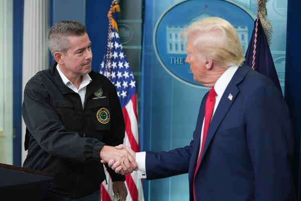 President Donald Trump shakes hands with Transportation Secretary Sean Duffy in the James Brady Press Briefing Room at the White House, Thursday, Jan. 30, 2025, in Washington. (AP Photo/Jacquelyn Martin)