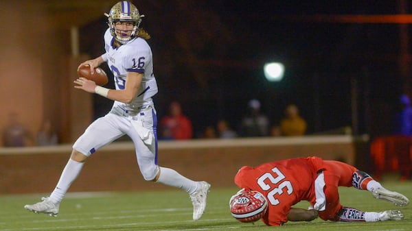  (College Park, Ga. -- Cane junior QB Trevor Lawrence #16 avoids a tackle by Woodward Academy senior DE Terry Myrick #32 during the second half of their GHSA quarterfinal game Friday, November 26, 2016. SPECIAL/Daniel Varnado)