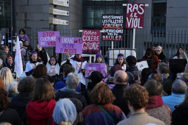 Activists hold posters in front of the Palace of Justice during a women's rights demonstration, Saturday, Dec. 14, 2024 in Avignon, southern France, where the trial of dozens of men accused of raping Gisèle Pelicot while she was drugged and rendered unconscious by her husband is taking place. (AP Photo/Aurelien Morissard)