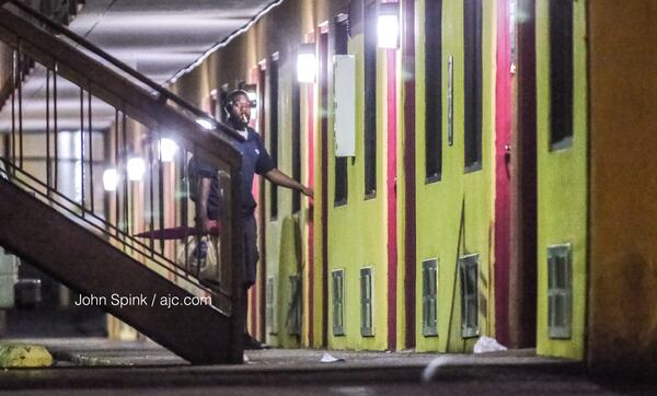 A man leaves his room just doors down from where a victim was shot to death at America Best Value Inn on Candler Road.