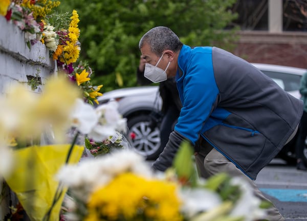 Zhaoren Li places flowers at the makeshift memorial outside of the Gold Spa in Atlanta last week. American Psychological Association president Jennifer Kelly issued a statement last week saying the Atlanta shootings “struck at the heart of the Asian American/Pacific Islander community." (Alyssa Pointer / Alyssa.Pointer@ajc.com)