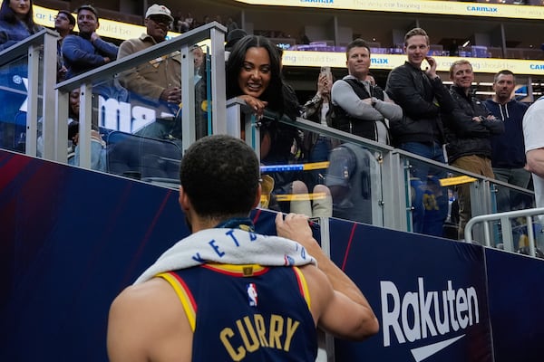 Golden State Warriors guard Stephen Curry, foreground, talks to his wife Ayesha Curry after the team's victory over the Sacramento Kings in an NBA basketball game Thursday, March 13, 2025, in San Francisco. (AP Photo/Godofredo A. Vásquez)