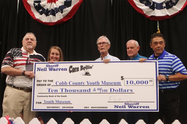 Cobb County Sheriff Neil Warren presents a $10,000 check to the Cobb County Youth Museum during the annual Corn Boilin’ event at Jim Miller Park. The event is Warren’s largest political fundraiser, and generates $10,000 a year for the Cobb Youth Museum. But the sheriff’s financial disclosures do not reveal how much the Corn Boilin’ raises for the sheriff’s political campaign. Christina Matacotta/Christina.Matacotta@ajc.com