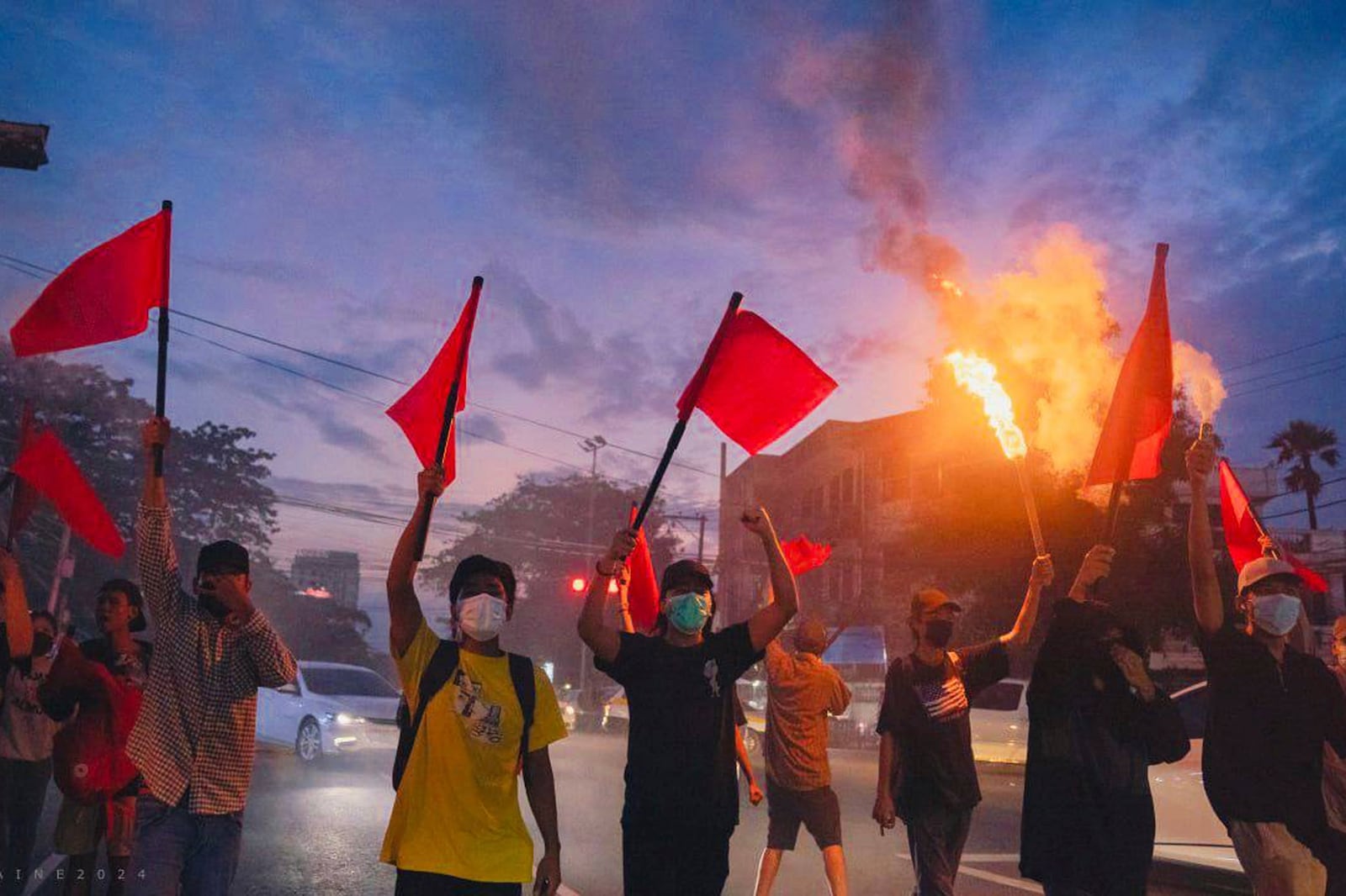 Pro-democracy protesters hold torches and flags during a flash mob rally to protest against Myanmar's military-government in Yangon, Myanmar on Sept.19, 2024. (Anti-Junta Alliance Yangon via AP)