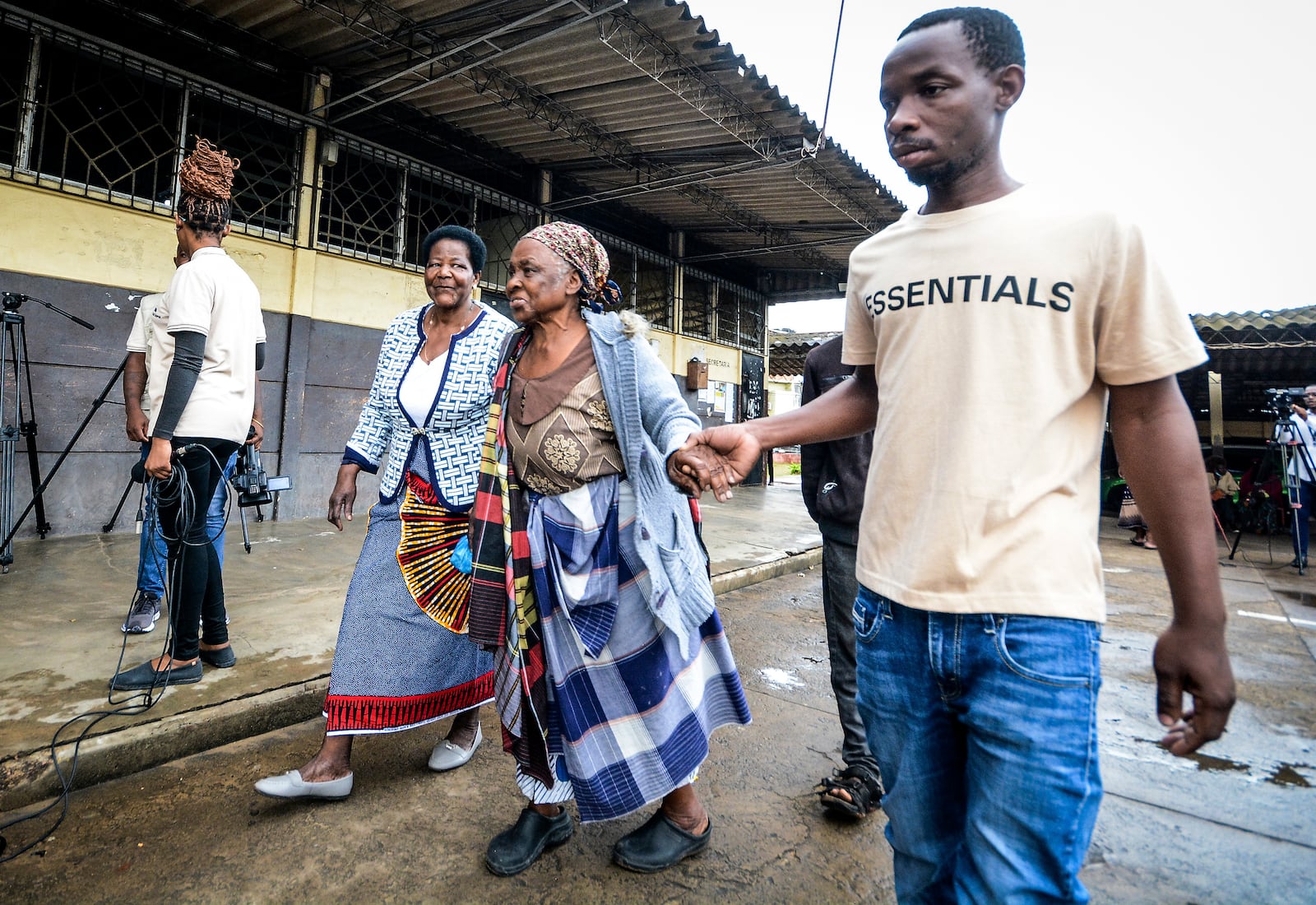 Women are helped as they arrive to cast their ballots at a polling station, in general elections in Maputo, Mozambique, Wednesday, Oct. 9, 2024. (AP Photo/Carlos Equeio)