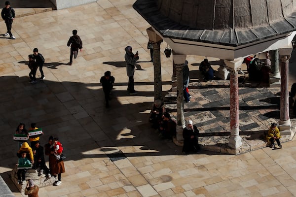 Syrians gather outside the 7th century Umayyad Mosque after Friday prayers in Damascus, Syria, Friday, Dec. 13, 2024. (AP Photo/Omar Sanadiki)