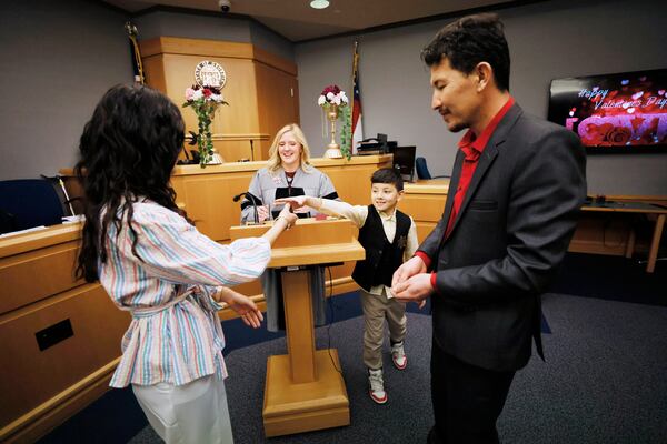 Samir Mohibi passed the wedding ring to Farida Jafari as she married Sharif Mohibi n Courtroom 1C of the Gwinnett County Courthouse in Lawrenceville on Valentine’s Day, Tuesday, February 14, 2023. Miguel Martinez / miguel.martinezjimenez@ajc.com