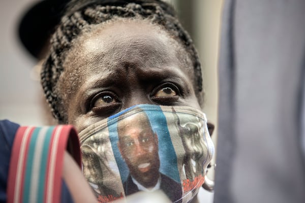 Ahmaud Arbery's aunt, Kim Arbery, listens to family attorney S. Lee Merritt speak with reporters in front of the Glynn County Courthouse after the preliminary hearing of Travis McMichael, Gregory McMichael and William Bryan, Thursday, June 4, 2020, in Brunswick, Ga. The three men are accused of shooting her nephew while he ran through their neighborhood in February. (AP Photo/Stephen B. Morton)