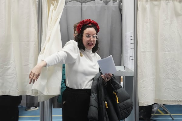 A woman walks out of a booth to cast her vote in parliamentary elections, in Nuuk, Greenland, Tuesday, March 11, 2025. (AP Photo/Evgeniy Maloletka)