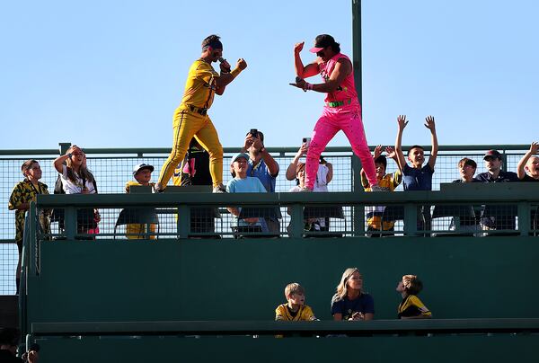 Bananas Bill LeRoy, left, and Party Animals Tanner Thomas do “rock, paper scissors” as they stand on the top seat of the Green Monster in center field at Fenway Park on Saturday, June 8, 2024. (John Tlumacki/Boston Globe)