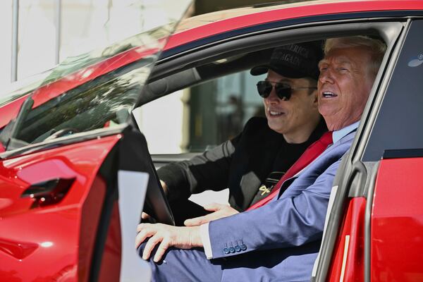 President Donald Trump and Tesla CEO Elon Musk speak to reporters as they sit in a red Model S Tesla vehicle on the South Lawn of the White House Tuesday, March 11, 2025, in Washington. (Pool via AP)