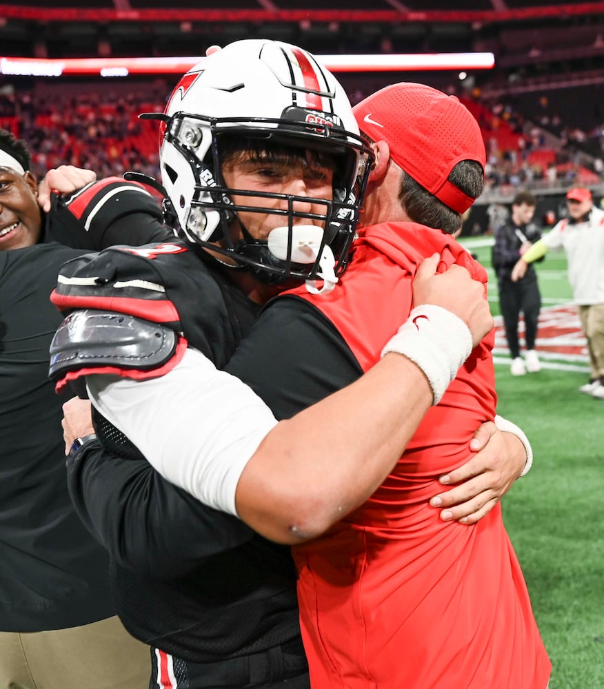 North Oconee quarterback Harrison Faulkner (1) hugs head coach Tyler Aurandt after beating Marist 14-7 during their Class 4A championship game at the Mercedes-Benz Stadium Monday, Dec. 16, 2024. (Photo/Daniel Varnado)