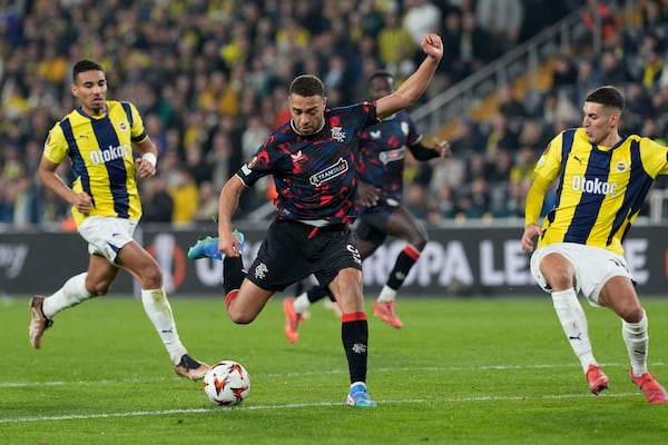 Rangers' Cyriel Dessers, center, attempts a shot at goal in front of Fenerbahce's Mert Muldur during the Europa League round of 16 first leg soccer match between Fenerbahce and Rangers at Sukru Saracoglu stadium in Istanbul, Turkey, Thursday, March 6, 2025. (AP Photo/Khalil Hamra)