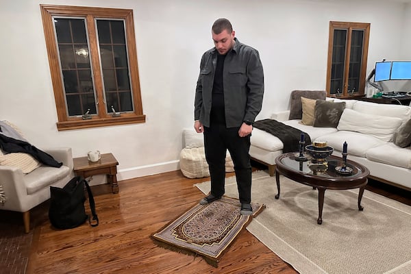 Karim Rahal prays in a home following an iftar meal Friday, March 7, 2025, in Dearborn, Mich. (AP Photo/Mike Householder)