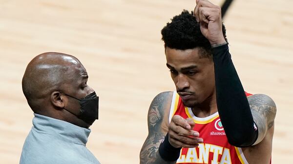 Hawks interim coach Nate McMillan (left) greets forward John Collins (20) before the team's game against the Miami Heat, Tuesday, March 2, 2021, in Miami. McMillan's opportunity to return to a head coach position comes with mixed feelings following Monday's firing of his friend, Lloyd Pierce. (Wilfredo Lee/AP)