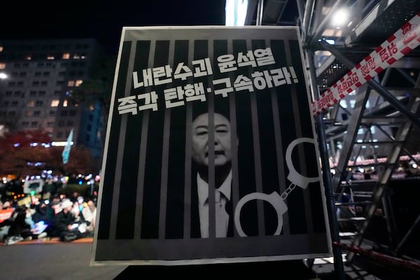 An image of depicting an imprisoned South Korean President Yoon Suk Yeol is displayed during a rally to demand his impeachment outside the National Assembly in Seoul, South Korea, Friday, Dec. 13, 2024. The signs read "Arrest and impeach the rebellion leader Yoon Suk Yeol." (AP Photo/Ahn Young-joon)