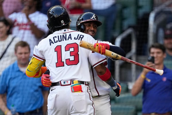 Atlanta Braves' Ronald Acuña Jr. (13) celebrates with Ozzie Albies after hitting a home run against the Minnesota Twins during the first inning of a baseball game Tuesday, June 27, 2023, in Atlanta. (AP Photo/John Bazemore)