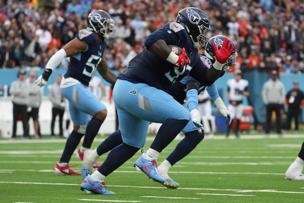 Tennessee Titans defensive tackle T'Vondre Sweat (93) runs with the ball after recovering a Cincinnati Bengals fumble during the first half of an NFL football game Sunday, Dec. 15, 2024, in Nashville, Tenn. (AP Photo/George Walker IV)