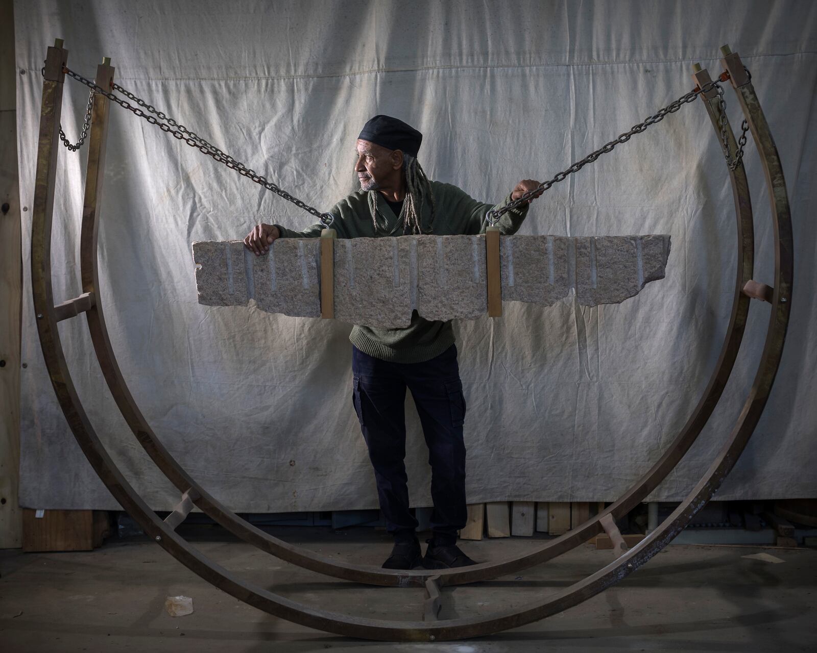 SAVANNAH, GA - FEBRUARY 07, 2024: Jerome Meadows is a sculptor, world-renowned for his public arts projects, stands behind his granite and bronze rocker piece titled, "The Rhythm of the Rock," at his studio, Wednesday, Feb. 7, 2024, in Savannah, Ga. (AJC Photo/Stephen B. Morton)
