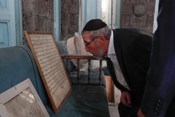 FILE - Rabbi Yusuf Hamra looks at an old Jewish scripture at the al-Franj synagogue where he used to serve as a rabbi in the old city of Damascus, Feb. 18, 2025. The Syrian-American Jewish family returned for the first time since emigrating from Syria to the United States more than three decades ago. (AP Photo/Omar Sanadiki, File)