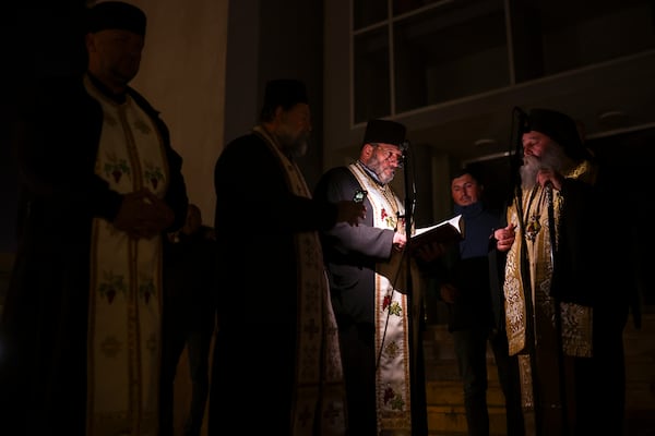 Priests read prayers during a vigil in the town of Kocani, North Macedonia, Tuesday, March 18, 2025 following a massive fire in a nightclub early Sunday. (AP Photo/Armin Durgut)