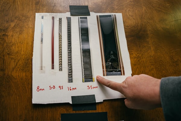 John Woodson, a projectionist, points to a 35mm film sample while demonstrating the format used for the showing of Anora. at the Tara Theater in Atlanta, Georgia on Friday, March 7, 2025. (Olivia Bowdoin for the AJC). 