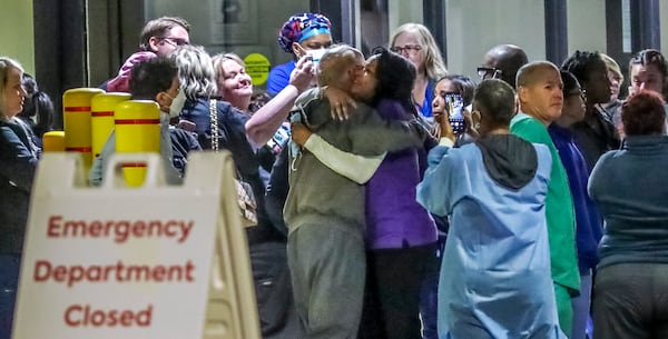 Medical workers embraced one another after closing Atlanta Medical Center’s emergency room on Friday, Oct 14, 2022. (John Spink / John.Spink@ajc.com) 

