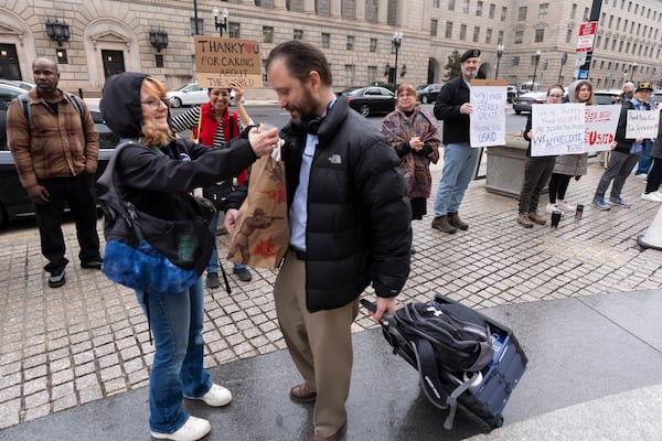 United States Agency for International Development (USAID) worker Donato Corsini carries personal belongings after retrieving them from USAID's headquarters in Washington, Thursday, Feb. 27, 2025. (AP Photo/Manuel Balce Ceneta)